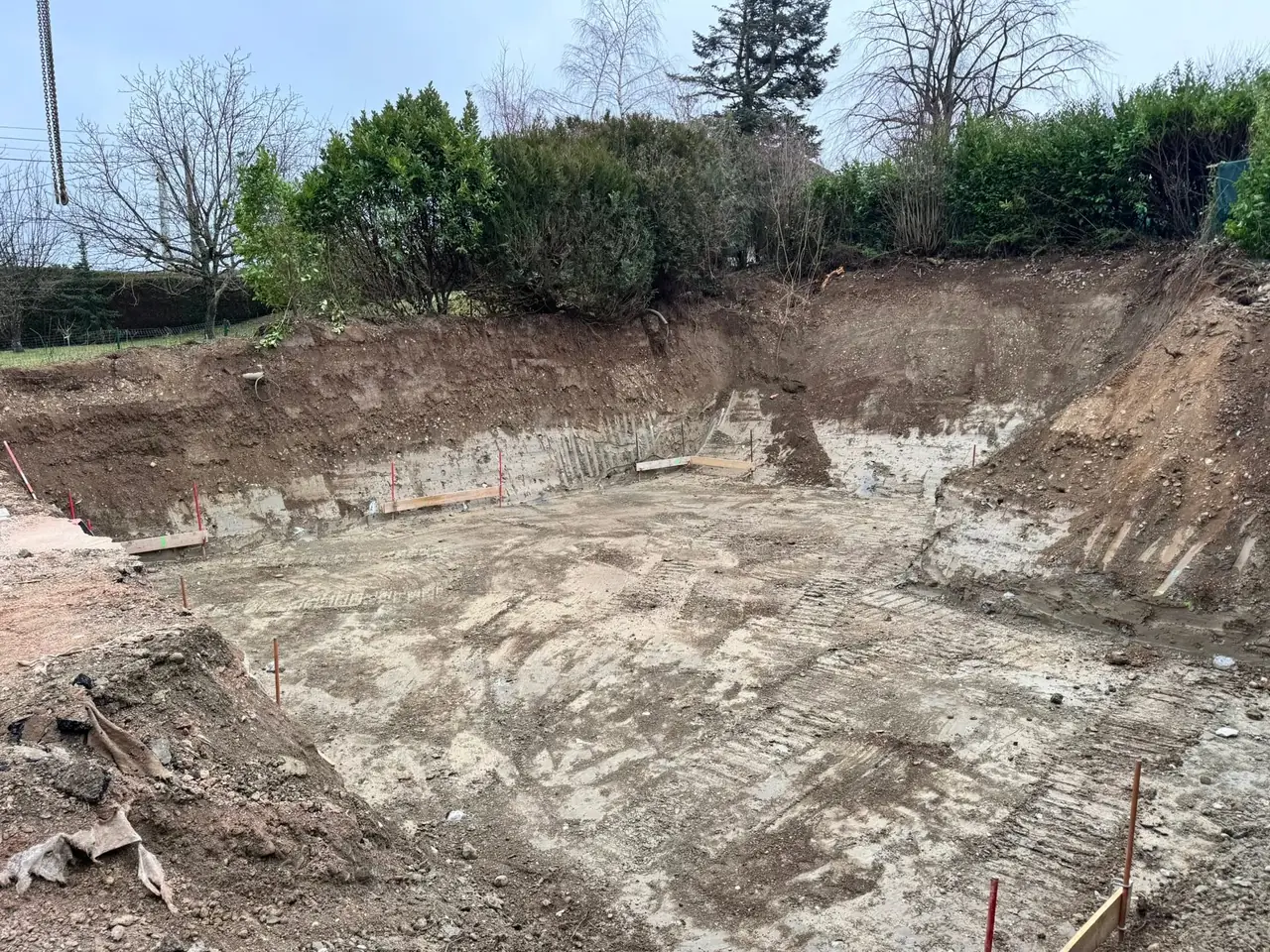 Fouille terrassée en pleine masse, chaises d’implantation posées sur son pourtour, avant les fondations.
