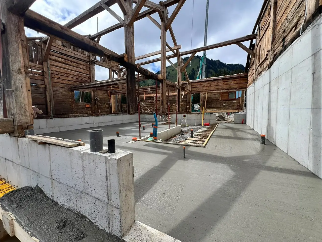 Murs et dalle en béton coulés sous la charpente d’origine d’un vieux chalet